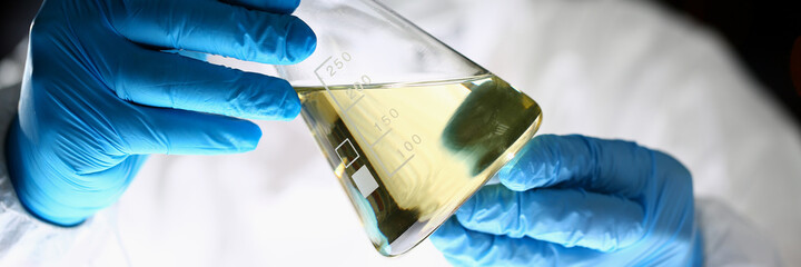 Attentive scientist wearing protective uniform while working with reagents in the laboratory