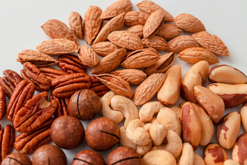 Pecans, brazil nuts, cashews, almonds and macadamia nut. Proper nutrition composition of assorted nuts pattern vertical photo for banner, article or packaging. Flat lay