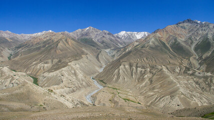 View of the snow-capped Wakhan mountain range in Afghanistan in high-altitude desert between Langar and Khargush, Gorno-Badakshan, Tajikistan Pamir