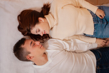 A young couple in love in a photo studio. Christmas scenery, guy and girl love each other. Posing for models in the studio on New Year's Eve Teenagers