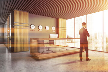 Man near reception desk with clocks