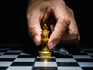Human hand moving king chess piece at table