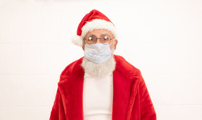 Serious Santa Claus in medical face mask warning about danger of Covid-19  respiratory infection and calling people for self-isolation at home. Xmas. New Year.