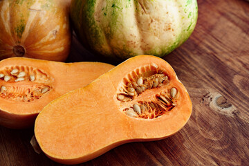 Pumpkin cut into halves on dark wooden table