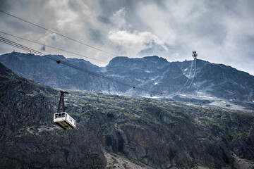 une télécabine dans les alpes sous un ciel d'orage