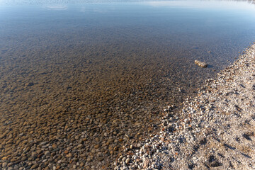 Chiemsee Strand  im Winter  bei Windstille und mit Steinen