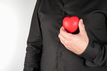 Heart diseases. Man holding red heart at chest. Health concept