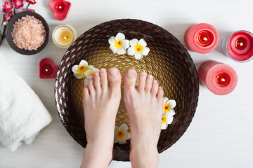 Female feet at spa pedicure procedure at beauty salon.