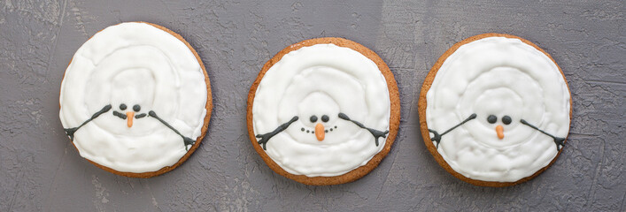 Melted Christmas cookies in the shape of a snowman, isolated on gray background