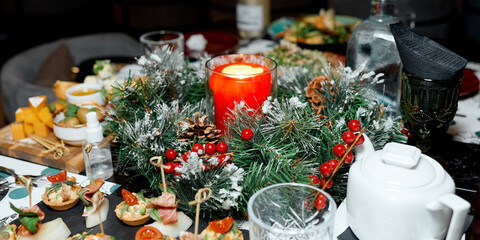 Festive table decorated with spruce candle in New Year and Christmas