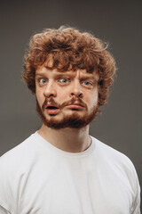 Shocked, amazed. Young man with dual emotions combination on face isolated on dark background, emotional and expressive. Concept of phycology, mental health, person unique, facial expression, sales