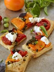 Puff pastry tomato tart with cottage cheese, pesto and basil, vertical