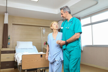 Obraz premium Doctor or assistance staff talking and support an elder patient woman while try to walking in the hospital