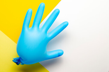 Blue medical glove inflated on yellow back