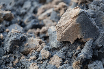 The texture of the wet stuck together sand on the river bank.