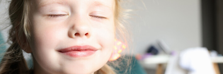 Little girl with closed eyes smiles and holds pens together. Childhood dreams and fantasies concept