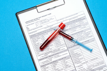 Clipboard with paper blank form with blood test tubes on blue background