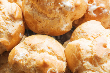 Homemade fresh baked golden profiteroles with cream. Custard cake. Food closeup background.