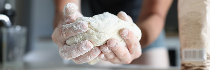 Male hands knead the dough in flour. Homemade cooking concept