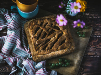 tea with pie. still life with cake and flowers on a wooden table. berries, and flowers on a brown wooden table. autumn still life with an appetizing cake and flowers on the kitchen table. autumn flowe