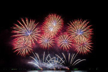 Obraz premium Colorful fireworks display over water at night