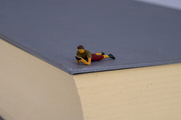 Obraz premium Small people reading on a book