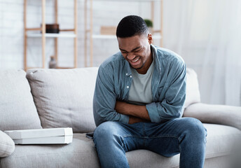Black Man Suffering From Stomachache After Eating Pizza At Home