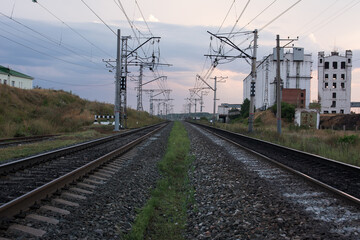 Fototapeta na wymiar Railway track, power lines and grain elevator