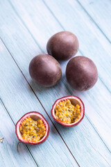 passion fruit on a blue wooden table, one is cut and ready-to-eat - 396088091