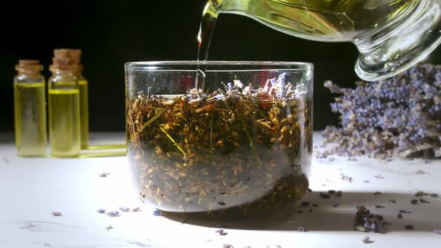 Preparing of lavender essential oil in glass on table