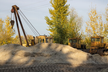 Bulldozers standing in the sand quarry. Construction site with working machines.