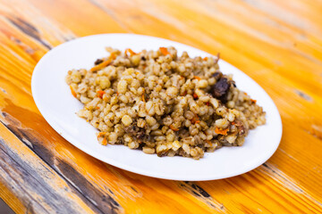 pearl barley porridge with mushrooms on a white plate