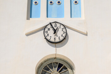 Close up of the clock on the facade of the Cathedral Church on Ios. Cyclades Islands, Greece