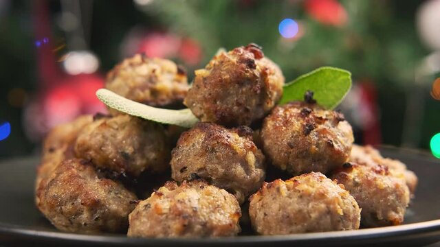 Christmas Pork stuffing meatballs with sage and onion. decoration, gifts, green tree branch. Rotating video