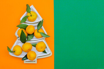Tangerines in the shape of a Christmas tree on an orange-green background