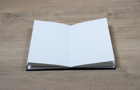 Cahier de croquis ouvert avec pages blanches sur fond bois