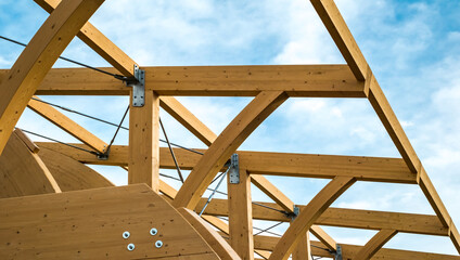 Obraz premium Detail of a modern wooden architecture in glued laminated timber on a blue cloudy sky