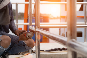 Workers using electric grinders to work outdoors without protective equipment, concept of work safety.