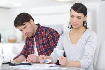portrait of worried couple paying bills