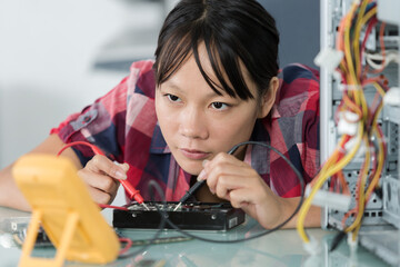 technician using multimeter to test computer component