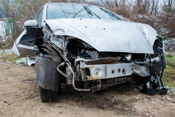 Obraz na płótnie Canvas Heavily damaged car near roadside after frontal collision close up shot.