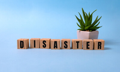 Disaster word written on wooden blocks on blue