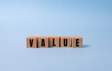 VALUE word written on wood block on blue background