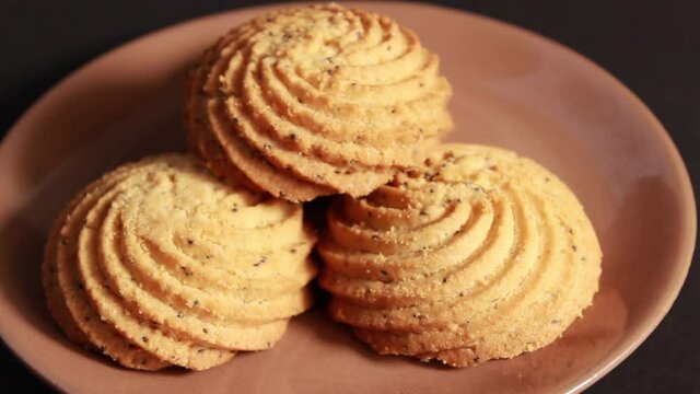 A woman's hand puts a shortbread on a saucer. Close-up, selective shot.