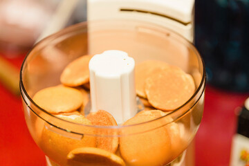 a vanilseveral wafer cookies in a food processor waiting to be ground up