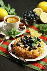 Belgian waffles with blueberry and a cup of tea with lemon