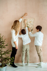 advent calendar hanging on the wall. gifts surprises for children. two emotional boys