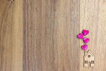 wooden background and small house with hearts
