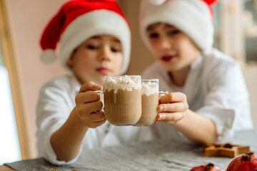 Child drink hot Christmas chocolate at home. Family with kids celebrate winter holidays.
