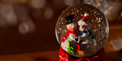 Two happy snowmen in a Christmas magic ball with snowflakes for a New Year background and greeting card. 